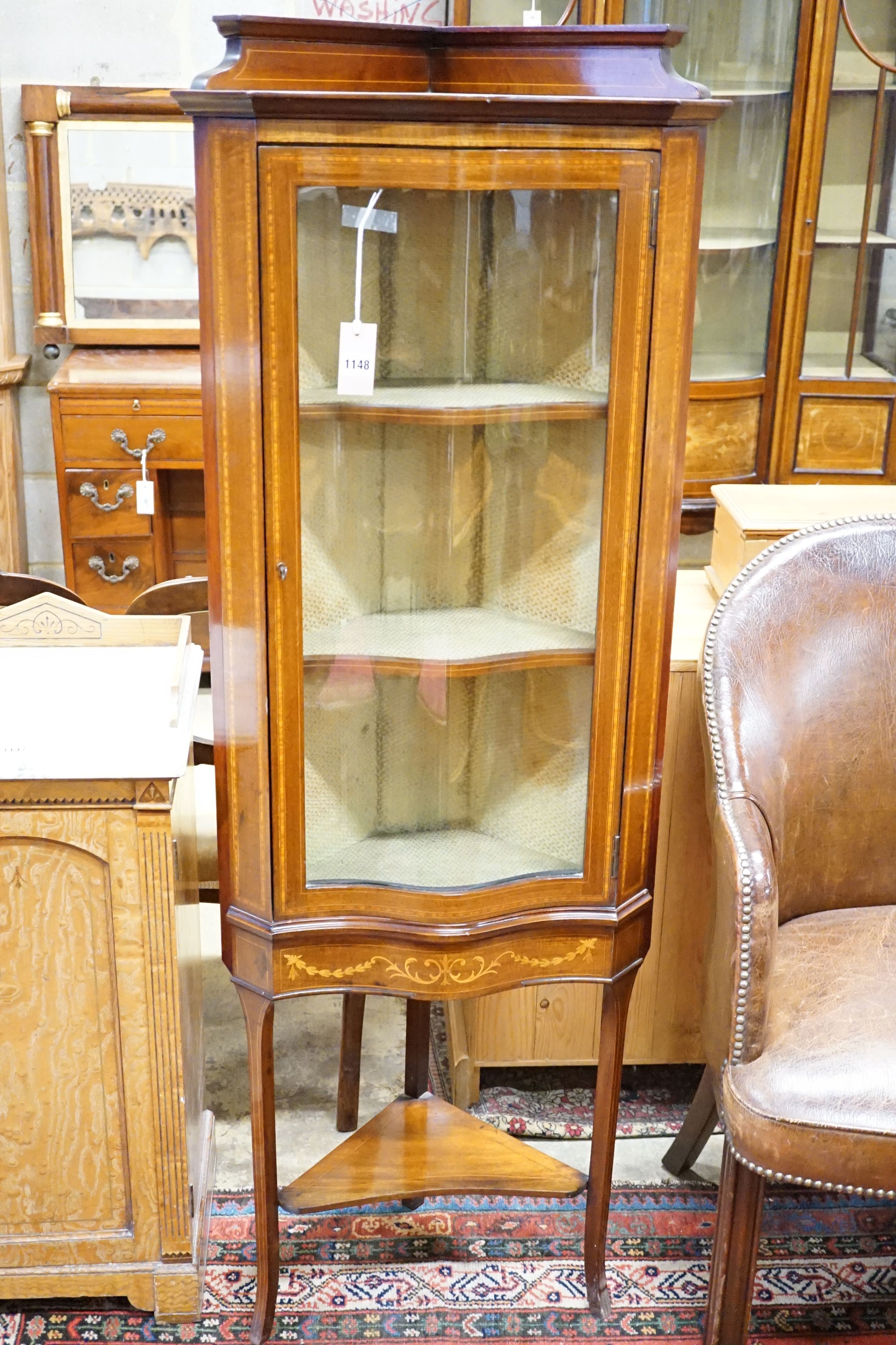 An Edwardian satinwood banded and inlaid mahogany standing corner display cabinet, serpentine fronted on slender legs, width 56cm, height 153cm